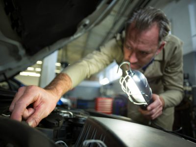 mechanic-examining-car-with-lampcvv